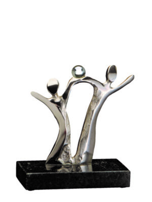 Troféu em metal prateado com base de granito preto, figuras humanas celebrando com uma esfera no topo