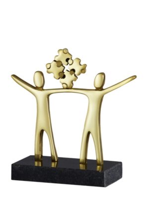 Troféu parceria em metal dourado com base de granito preto, dois bonecos segurando peças de quebra-cabeça